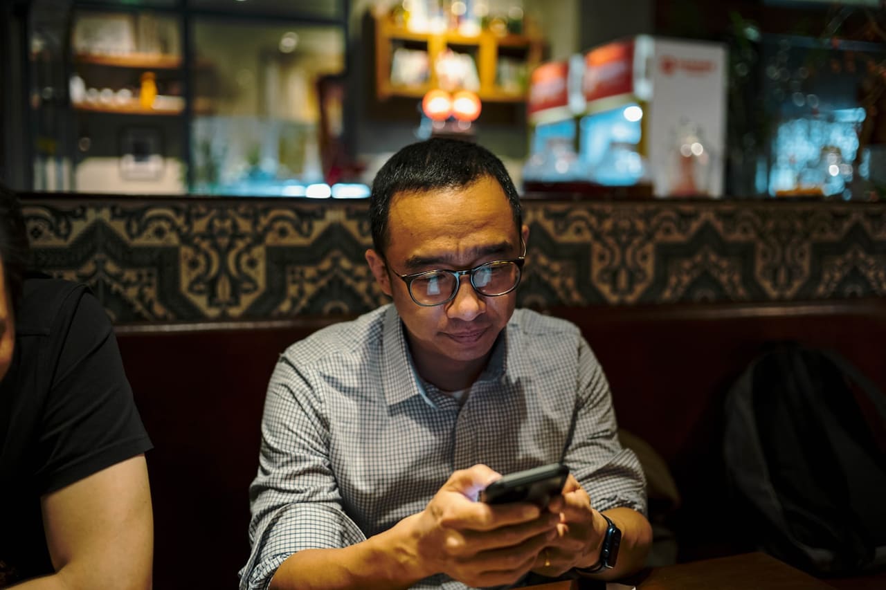Restaurateur consultant son tableau de bord de caisse entouré des outils de son établissement
