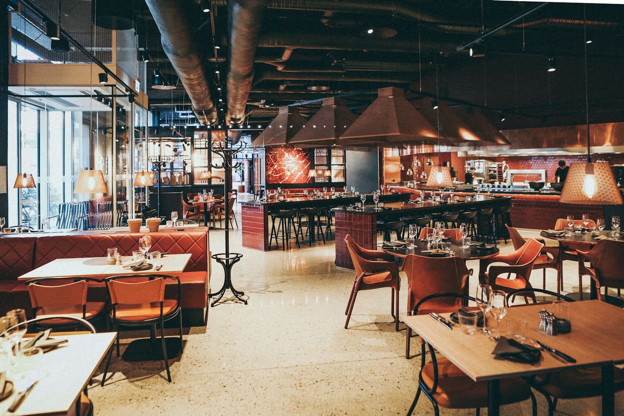 Serveuse encaissant une commande sur une caisse tactile au comptoir d’un restaurant